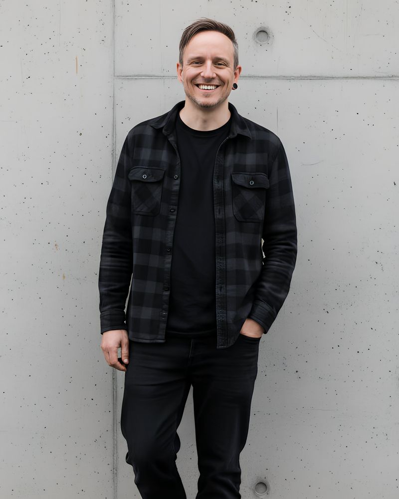 Björn Fischer lehnt lächelnd an einer Betonwand